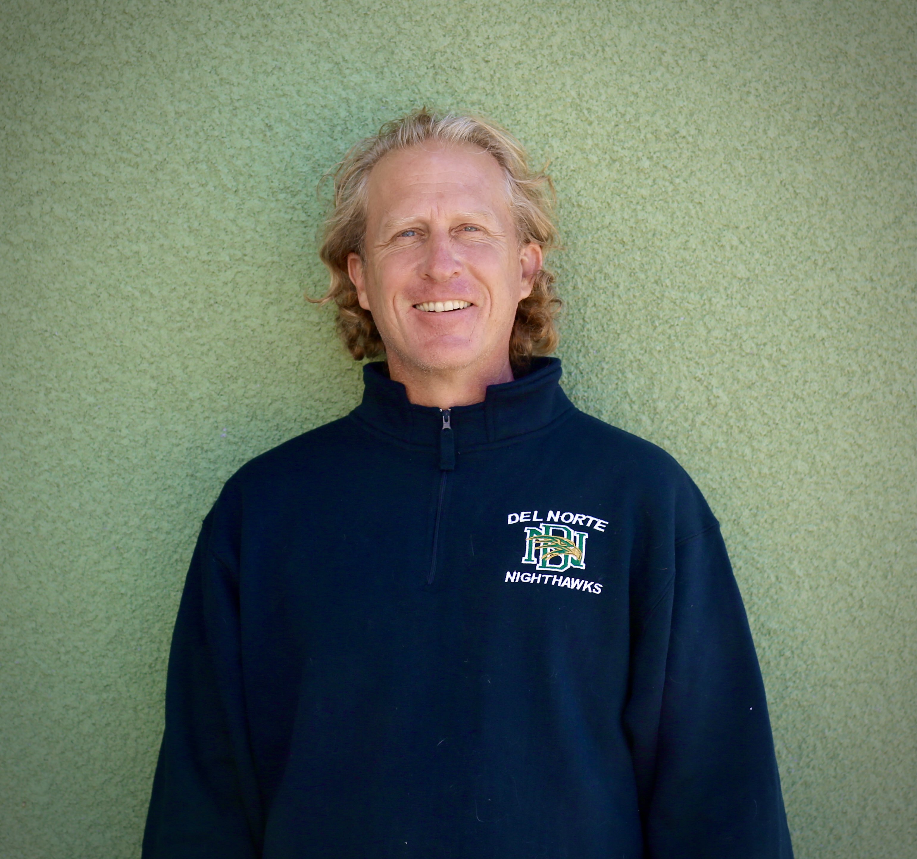 Mr. Krenz smiling front of a green wall